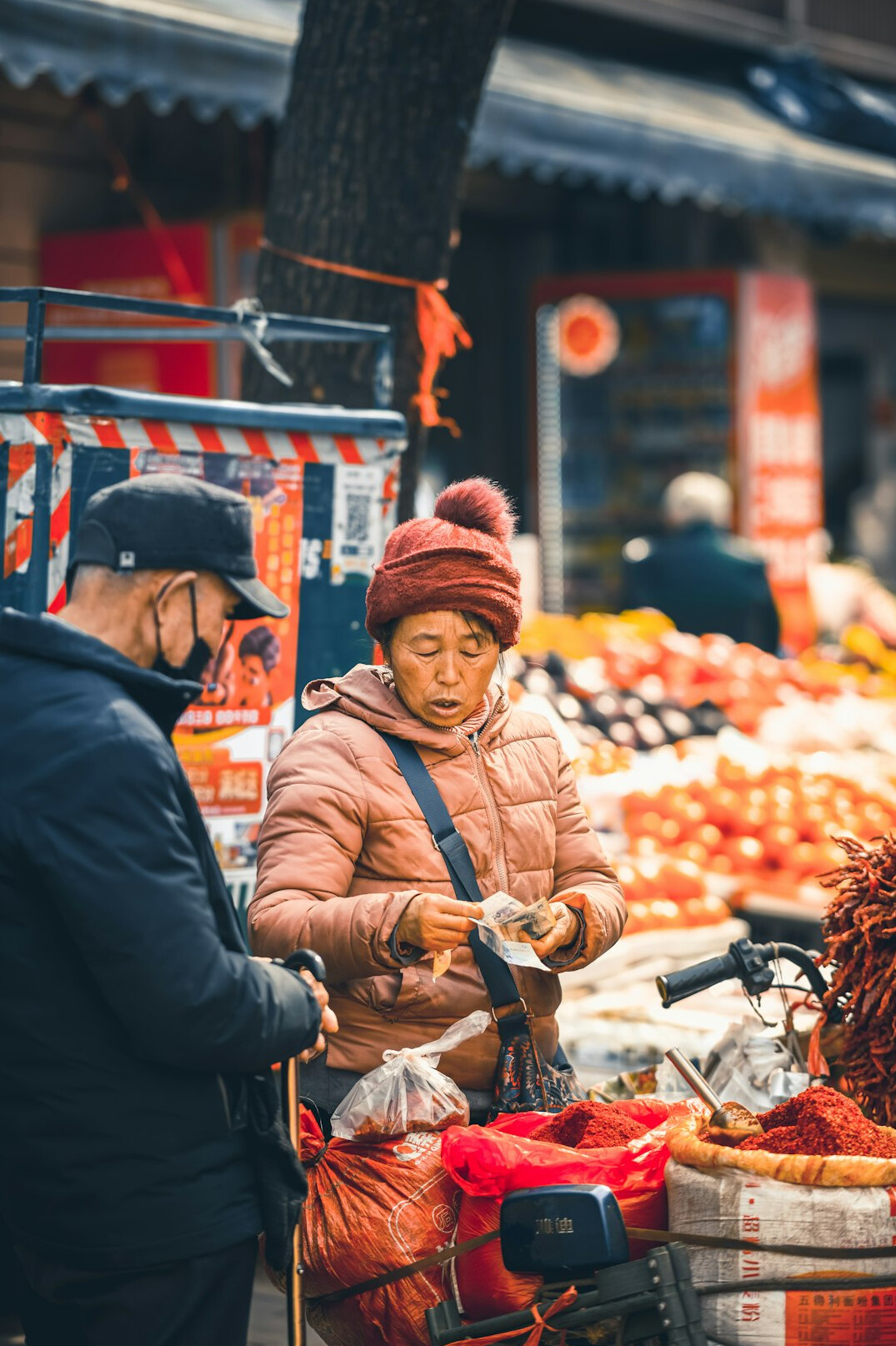 A vendor handing produce to a customer at a market stall