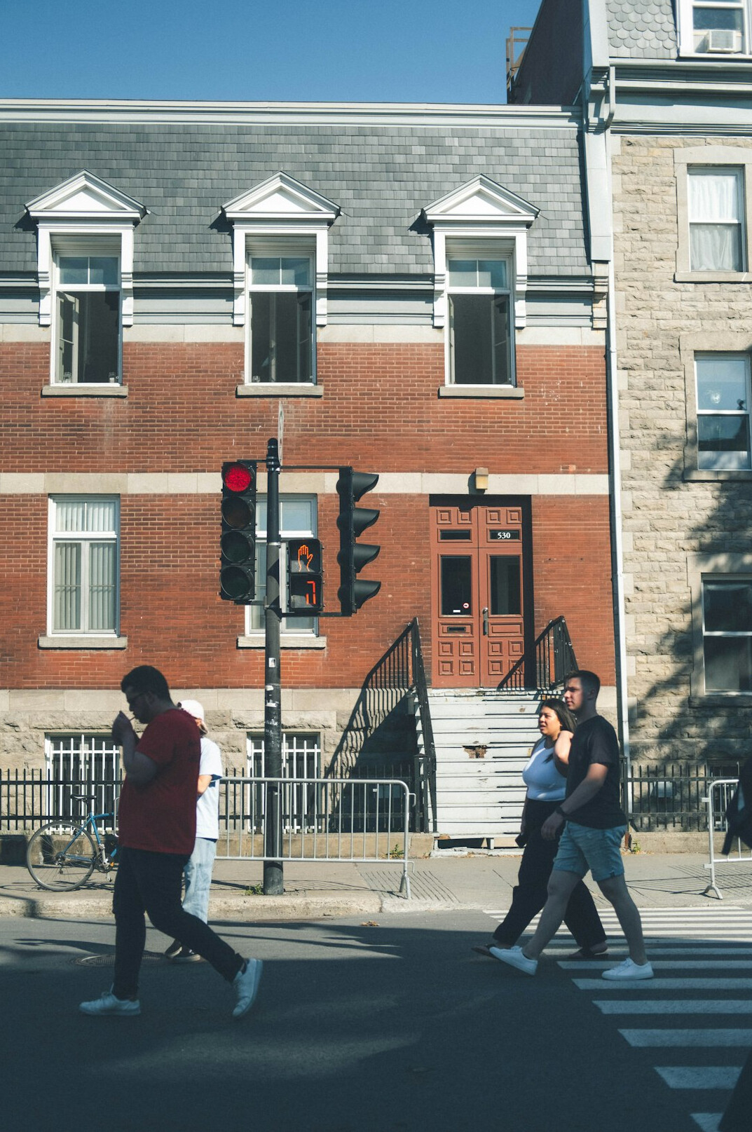 Pedestrians crossing a busy downtown street in a Canadian city